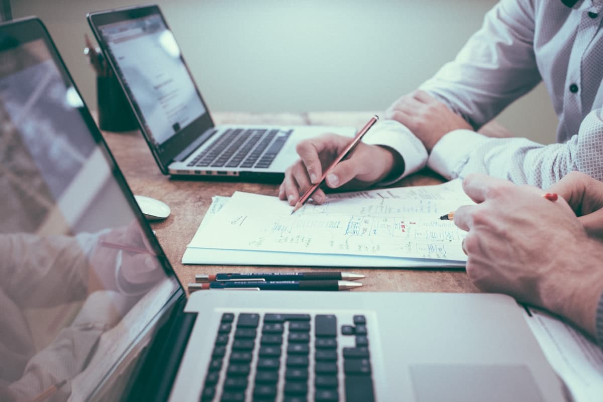 Pessoa trabalhando com documentos e laptop